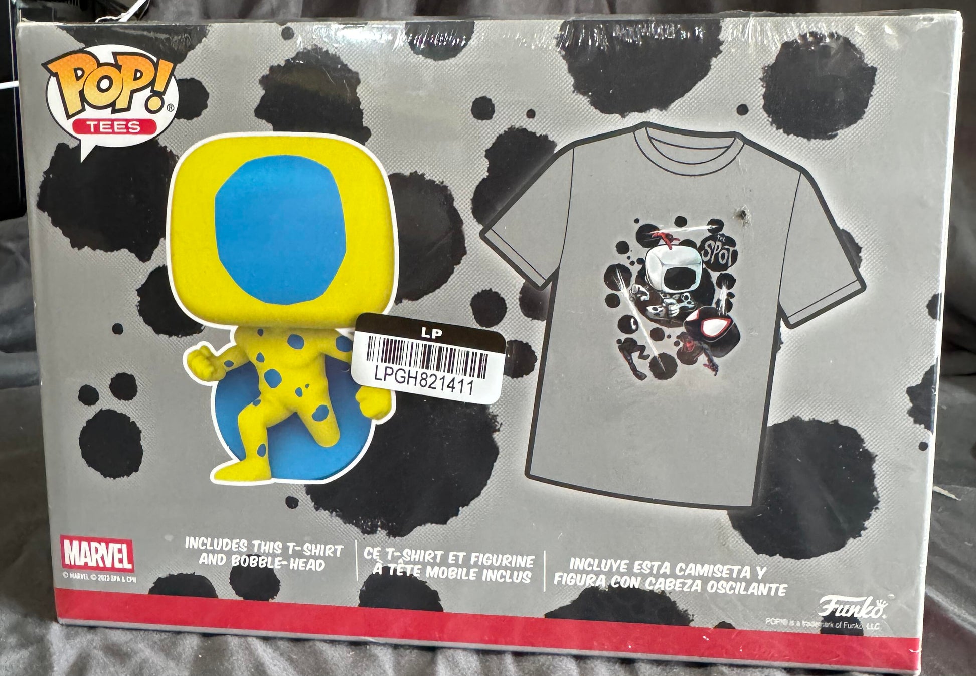 Funko Pop! Marvel t-shirt and plush toy packaging on a bed