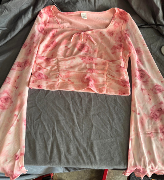 Pink floral long-sleeve top on a gray surface