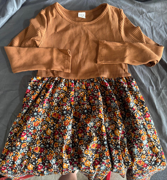 Brown ribbed crop top and floral skirt on a gray surface